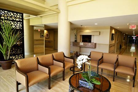 A contemporary waiting area featuring comfortable chairs and a decorative table with flowers.