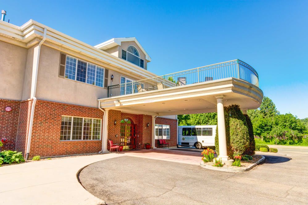 A large residential house with an extended driveway and a covered entrance.