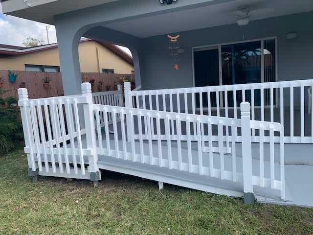 A white accessibility ramp leading to a patio area.