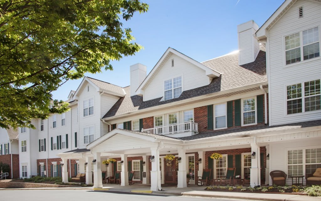 A traditional style hotel with a white facade and prominent columns at the entrance.