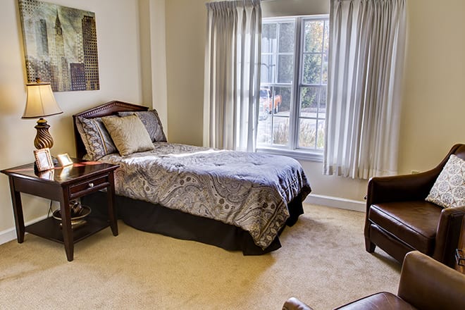 A cozy bedroom with a single bed and a large window.