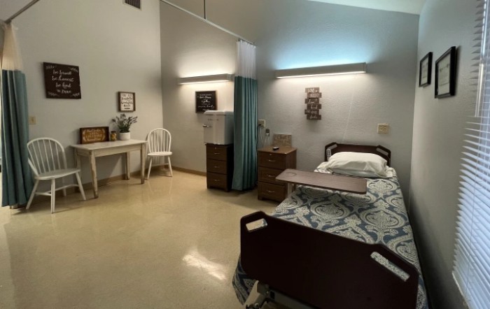 A well-organized hospital room with a bed and essential furniture.