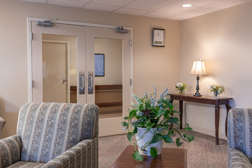 A cozy waiting area featuring comfortable seating, a decorative plant, and warm lighting.