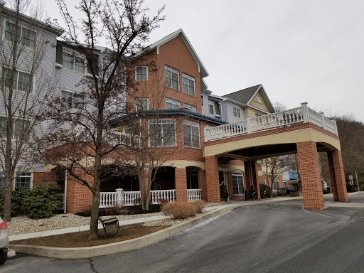 A charming residential building featuring a welcoming entrance and nearby trees on a cloudy day.