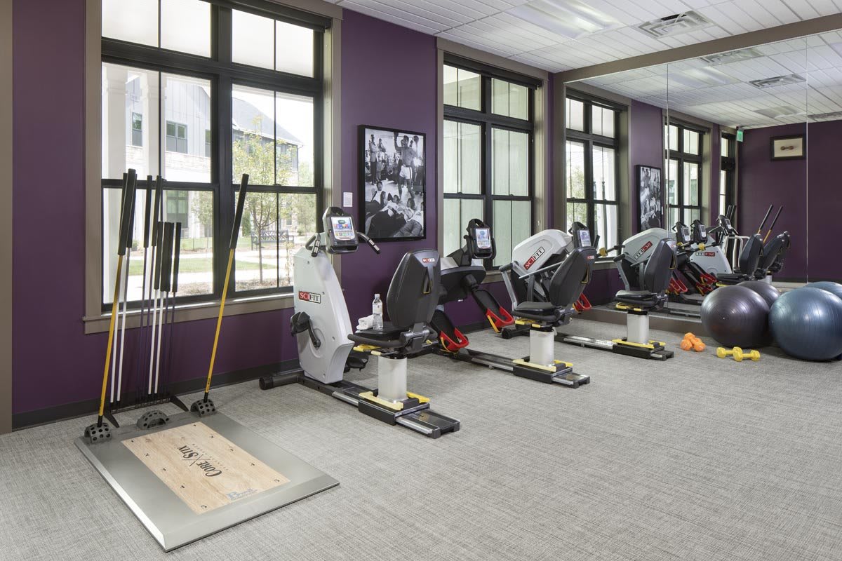 A well-equipped gym featuring exercise machines lined up against the wall.