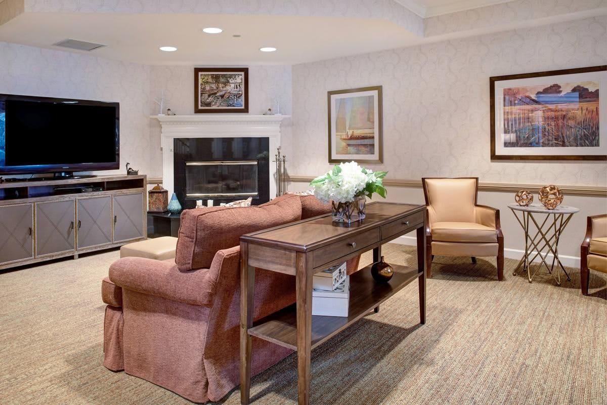 A cozy living room featuring a sofa, armchairs, a fireplace, and elegant decor.