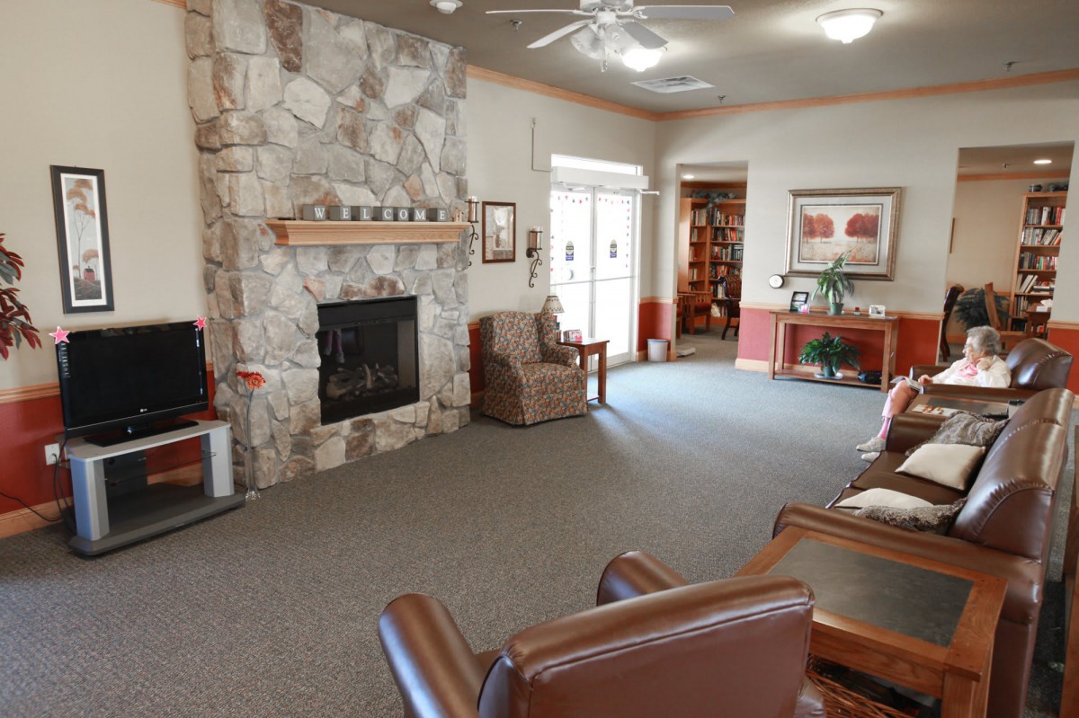 A cozy living room featuring a stone fireplace and comfortable seating area.