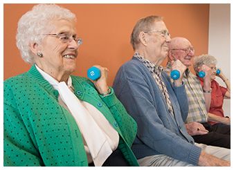 A group of seniors engaging in light weightlifting exercises as part of a healthy lifestyle routine.