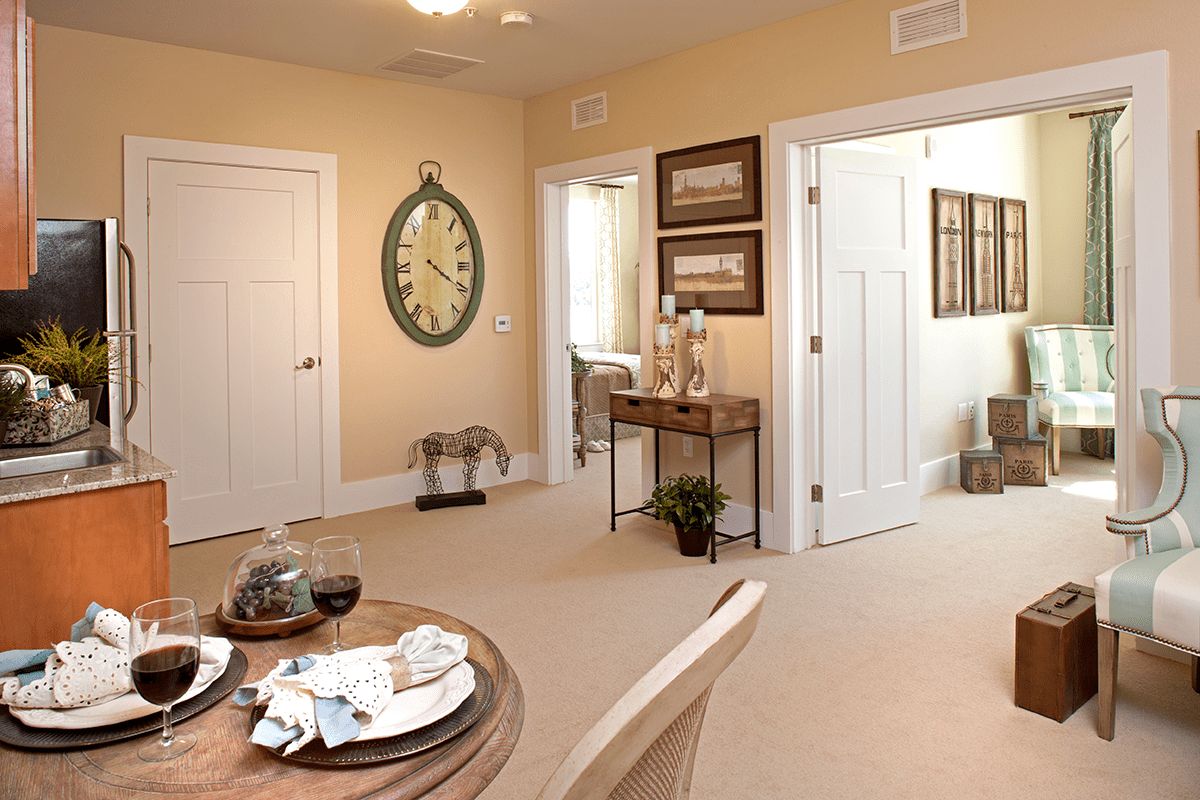 A cozy dining area featuring a clock on the wall, a neatly set table, and an adjoining hallway.