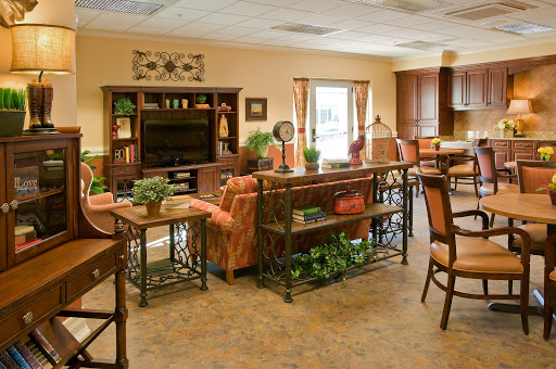 A cozy and well-decorated living room area with comfortable seating, plants, and a television.