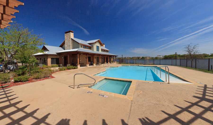 A serene residential outdoor area with a swimming pool under a clear blue sky.