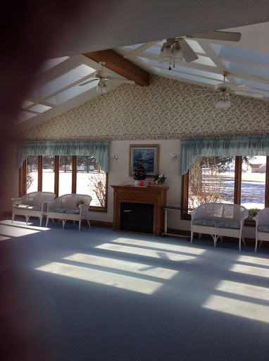 A bright and cozy interior space with large windows allowing sunlight to illuminate the room.