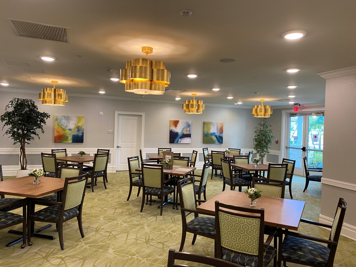 A spacious dining area with neatly arranged tables, chairs, and decorative lighting.