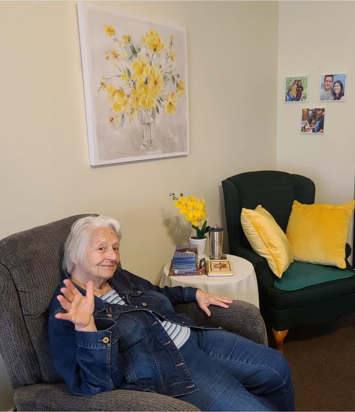 An elderly woman sits comfortably in a cozy living room, surrounded by cheerful decor.