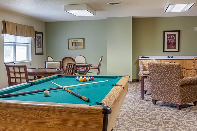 A cozy recreation room featuring a pool table and comfortable seating areas.