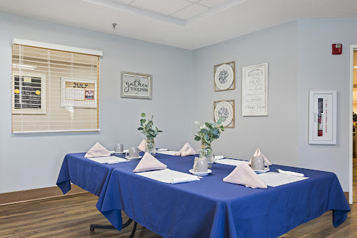 A well-arranged meeting room with a blue table setting, decorative flowers, and an inviting ambiance.