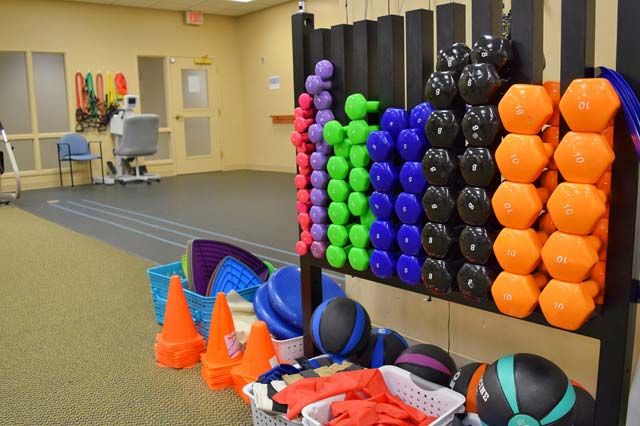 A gym area with colorful exercise equipment and accessories.