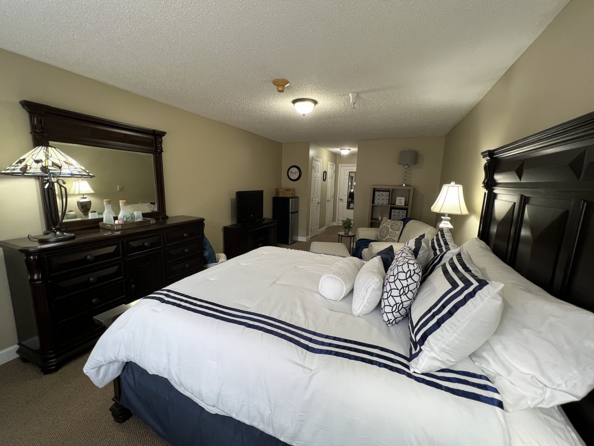 A neatly arranged bedroom with cozy bedding and elegant furniture.