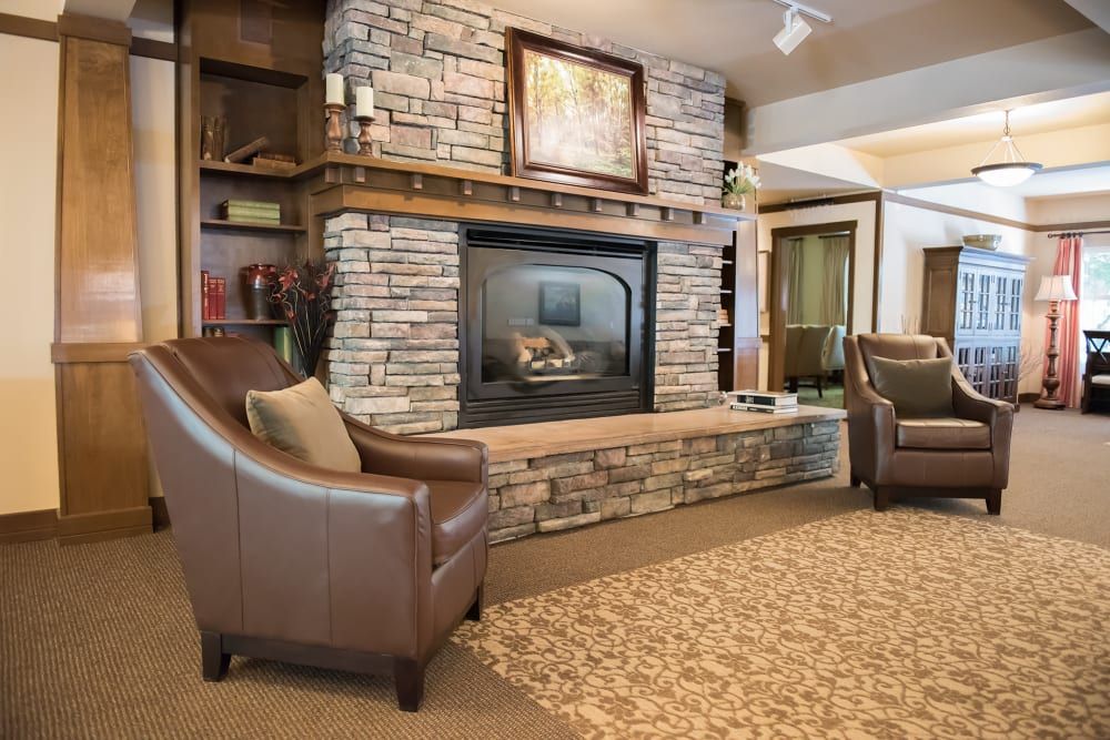 A cozy living room featuring a stone fireplace and comfortable seating.