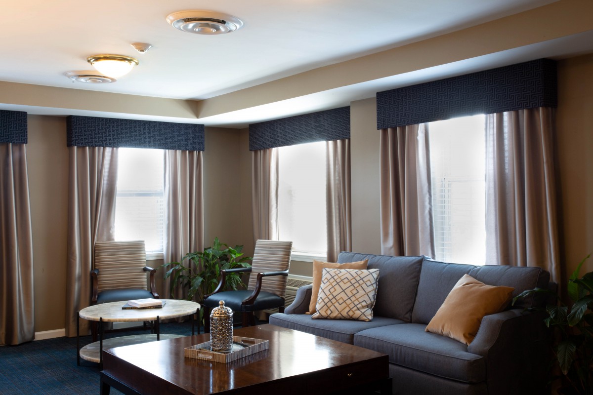A well-decorated living room featuring a comfortable sofa and elegant curtains.
