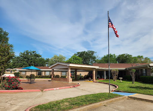 A well-maintained residential facility featuring an American flag and serene surroundings.