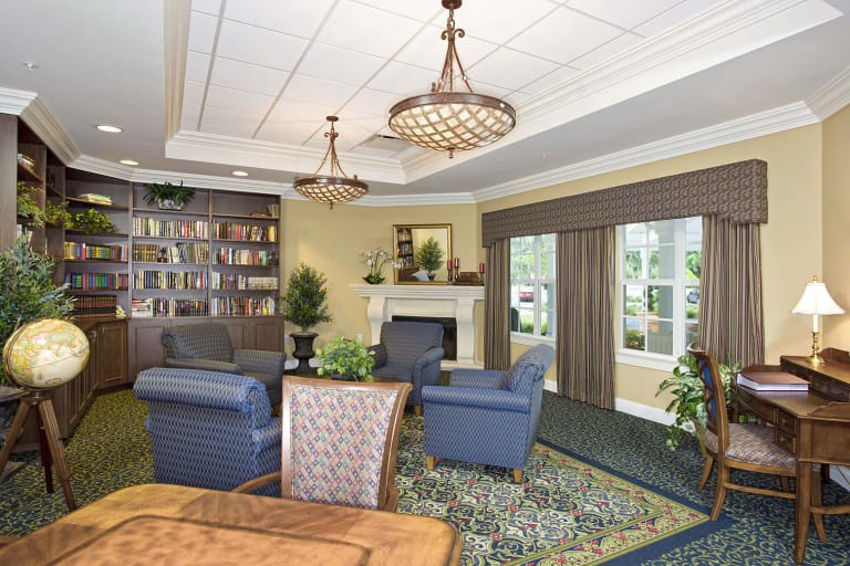 A cozy living room with armchairs, a fireplace, and built-in bookshelves.