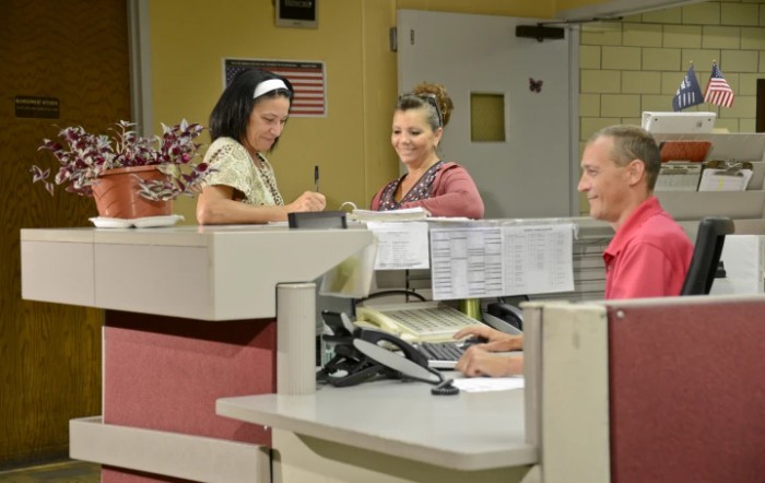 Hospital staff interacting at the reception desk.