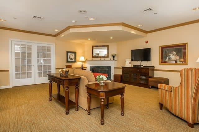 A cozy living room with elegant furniture, featuring a sofa, coffee table, and fireplace.