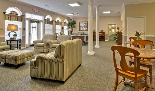 A spacious lobby area with comfortable seating, large windows, and elegant pillars.