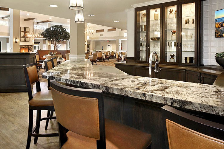 A modern bar area with a luxurious marble countertop and elegant seating.