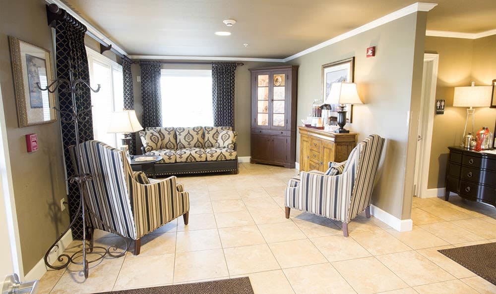 A cozy living room with a patterned sofa, striped chairs, and warm lighting.