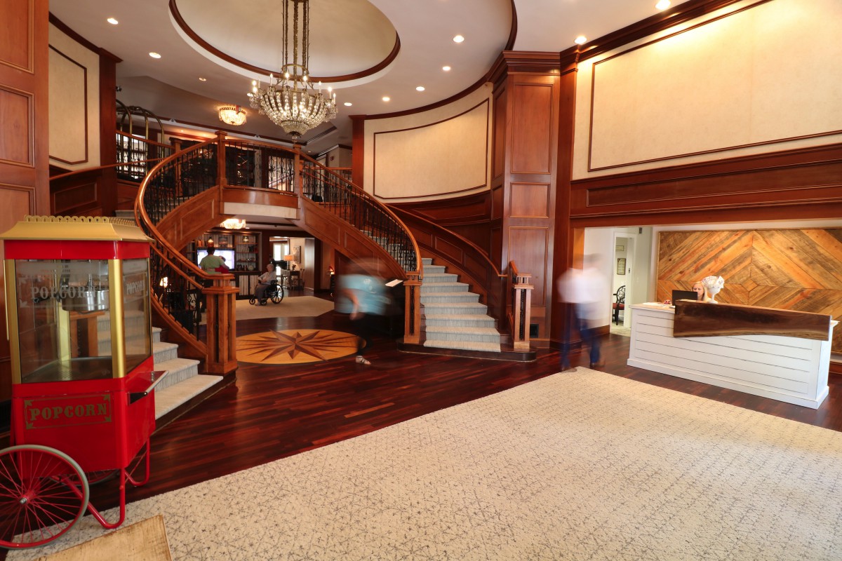 A luxurious hotel lobby featuring a grand staircase and elegant chandelier.