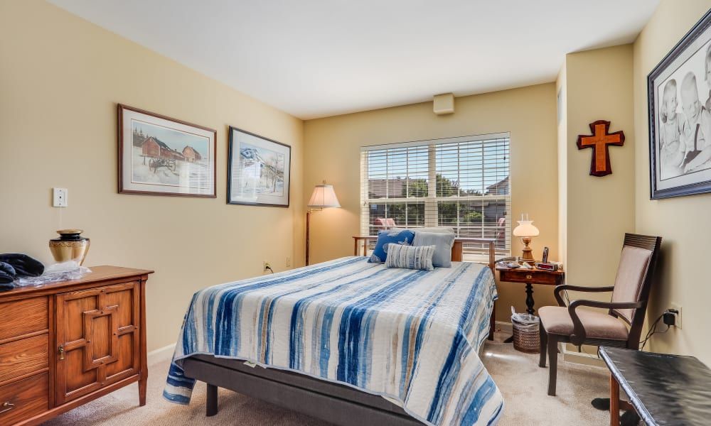 A cozy bedroom with striped bedding and ample natural light.