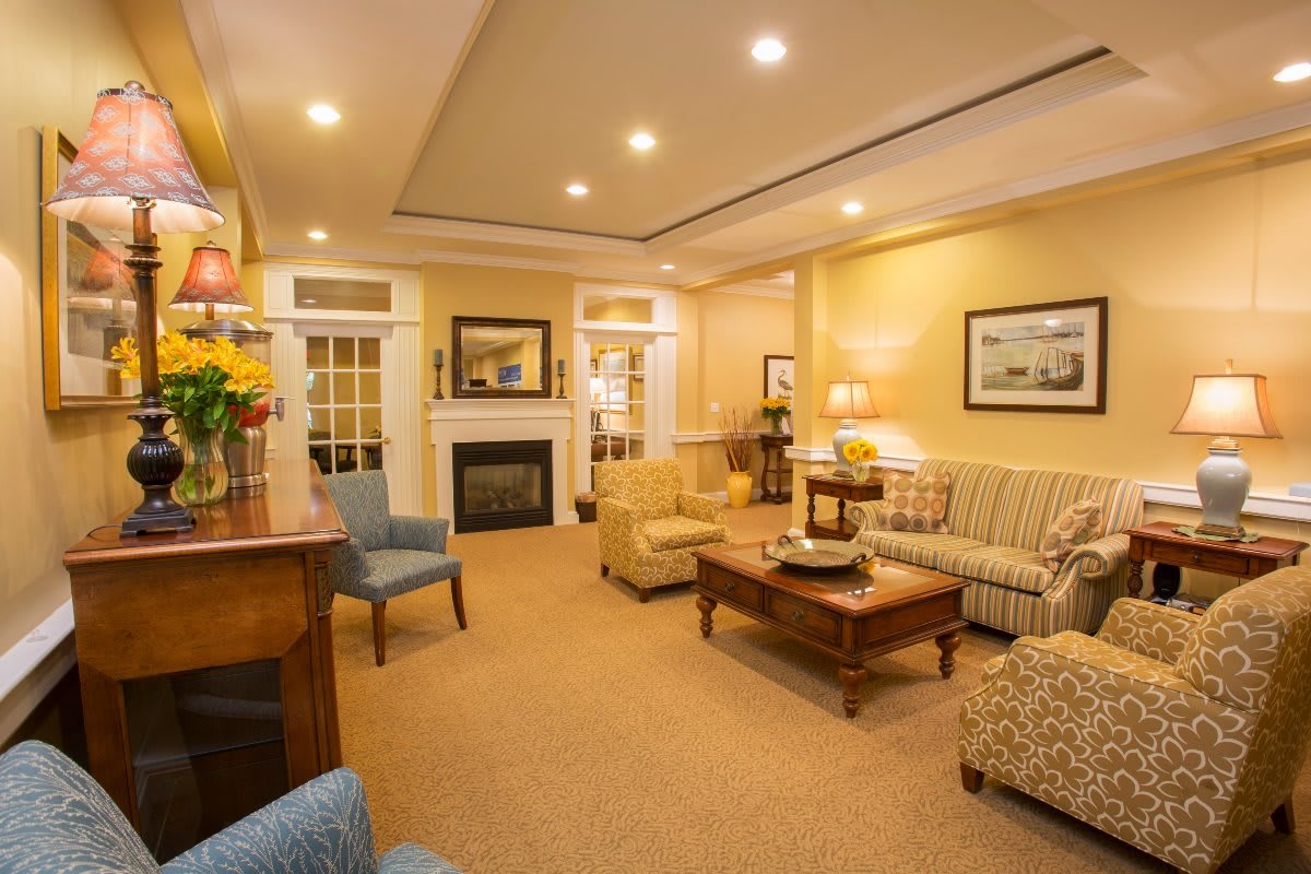 A cozy living room with various seating options and a fireplace.