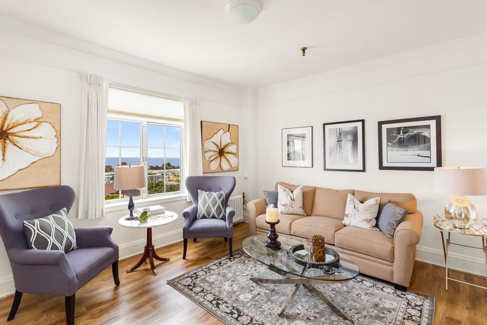 A cozy and elegantly decorated living room with comfortable seating and tasteful artwork.