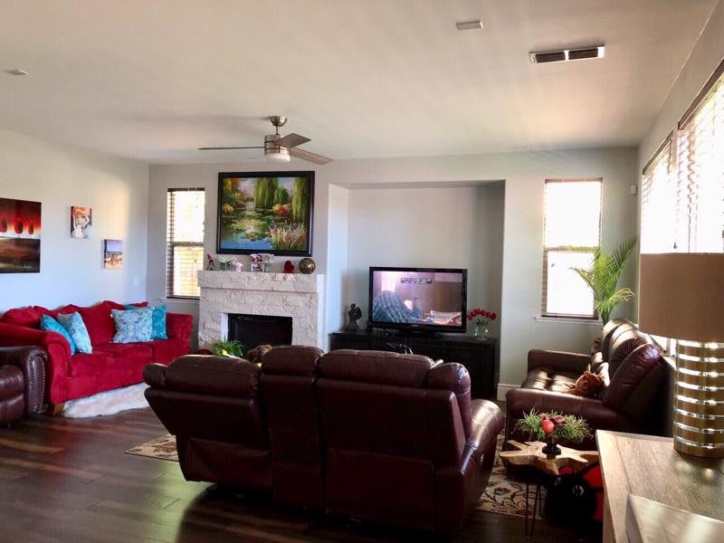 A cozy living room featuring a fireplace, leather sofas, and a television.