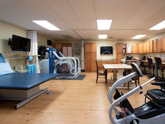 A physical therapy room equipped with various exercise machines and tools for rehabilitation.