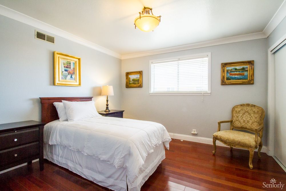 A cozy bedroom with a single bed and elegant decor.