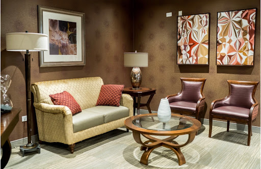 A cozy living room setup featuring a beige sofa, an armchair, a stylish coffee table, and decorative artwork.
