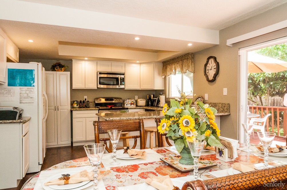 A cozy kitchen and dining area featuring a sunflower centerpiece on the table.