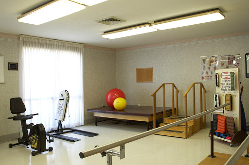 A well-equipped therapy room featuring exercise equipment and training aids for rehabilitation.