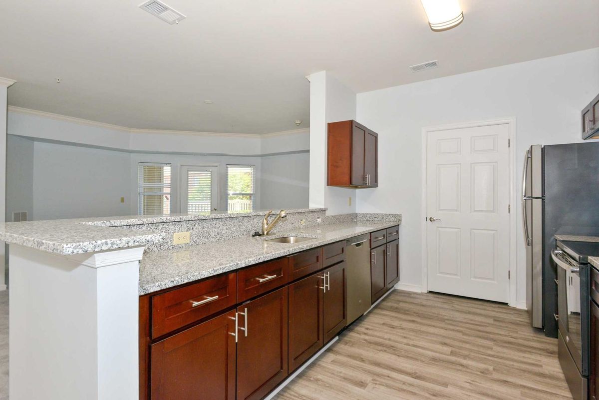 Modern kitchen with granite countertops and wooden cabinets.