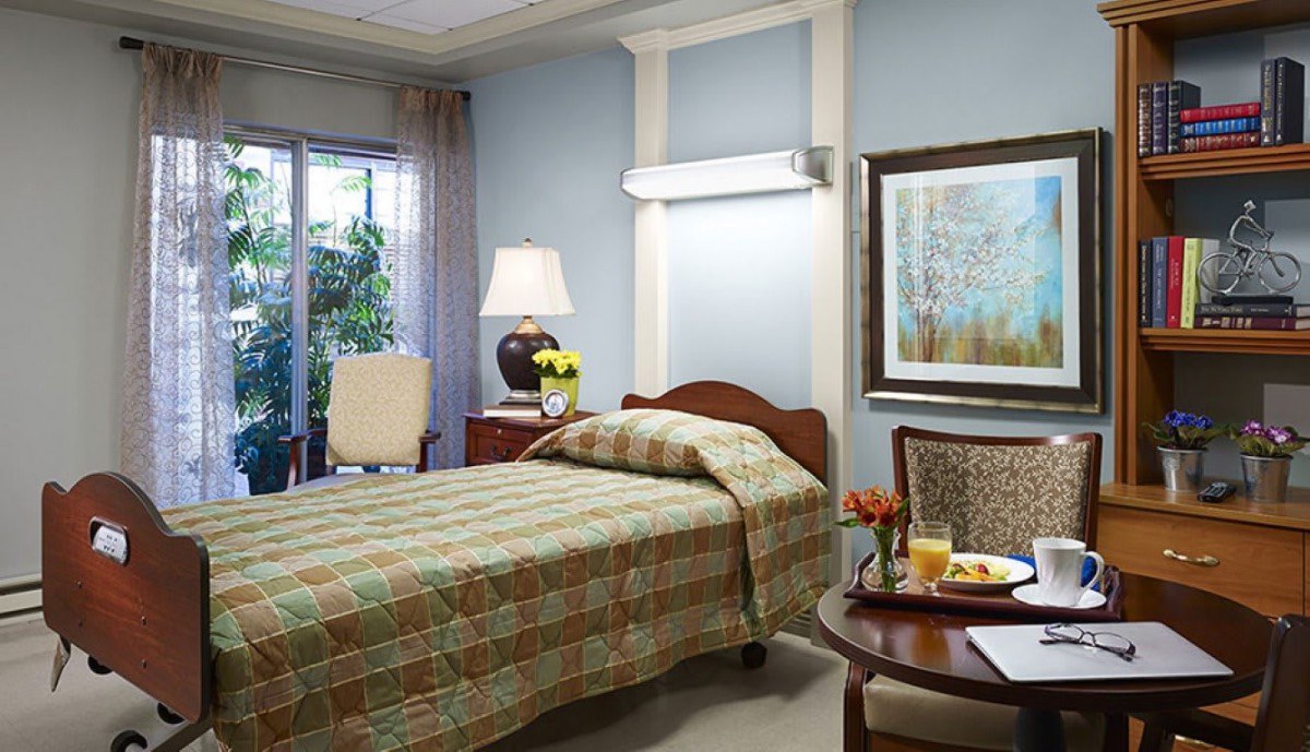 A cozy bedroom featuring a single bed, lamp, and decorative elements.