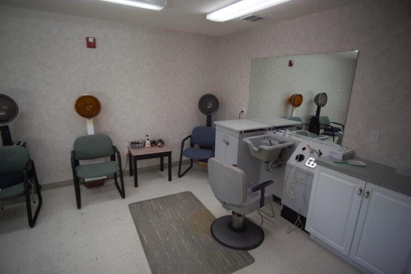 Interior of a small hair salon with styling chairs and hair dryers.