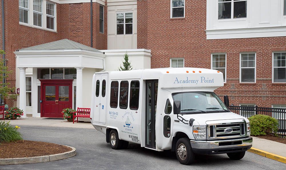 A shuttle bus parked in front of a building entrance.
