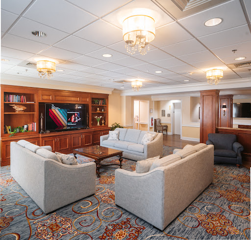 A well-furnished living room featuring comfortable sofas, a large television, and elegant lighting.