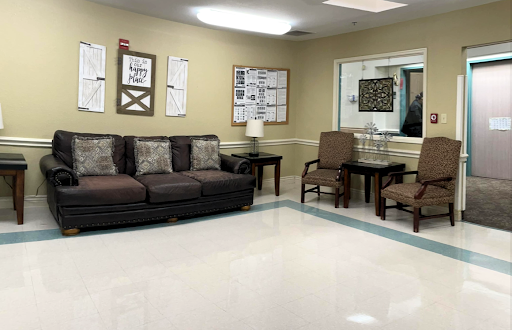 A cozy waiting area featuring a sofa, chairs, and decorative elements.