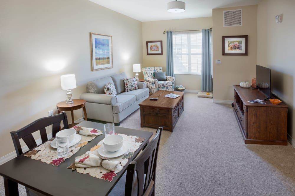 A cozy living room featuring a sofa and dining table, with tasteful decor and natural light.
