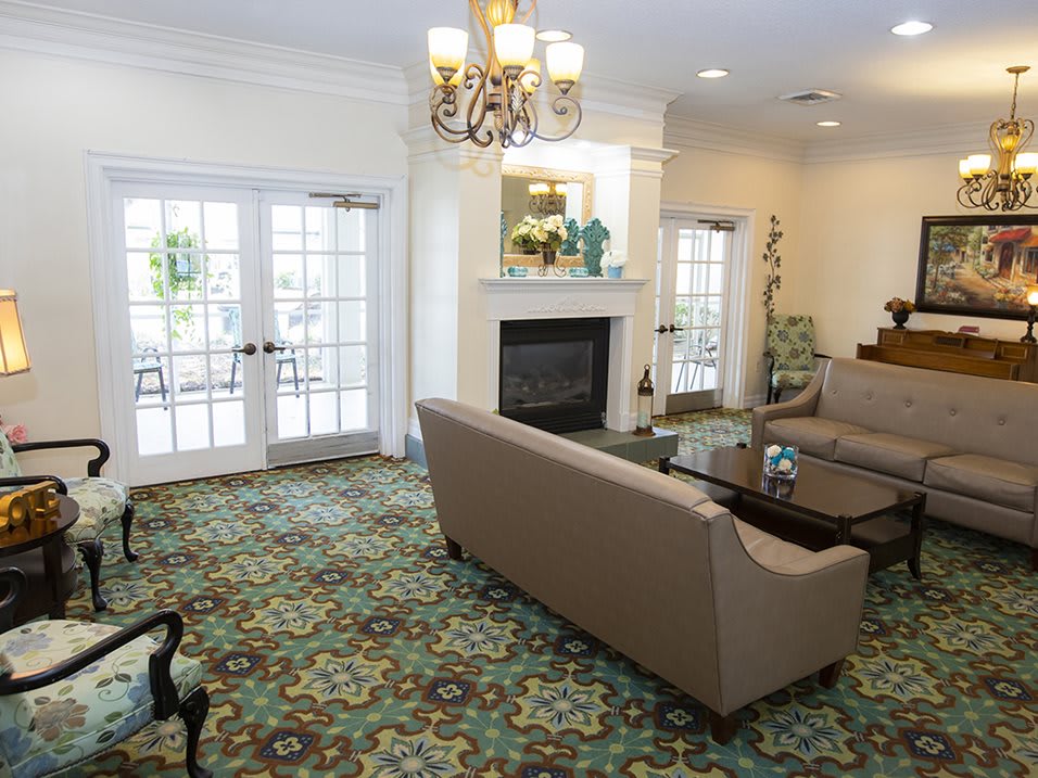 A comfortable living room with a sofa set, fireplace, and elegant chandelier.