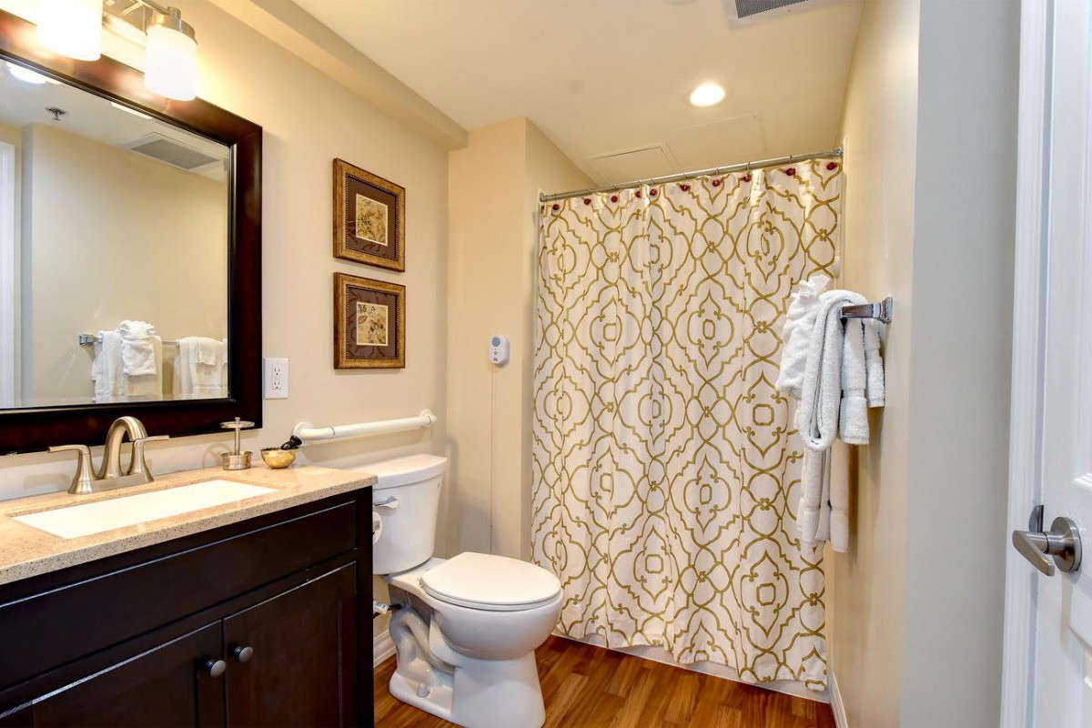 A well-organized bathroom with a patterned shower curtain and elegant decor.
